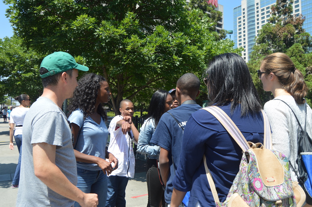Two of the three VMC teams run into each other outside of Olympic Centennial Park and discuss progress on their stories, as one group covers mass incarceration and the other takes on teen pregnancy.
