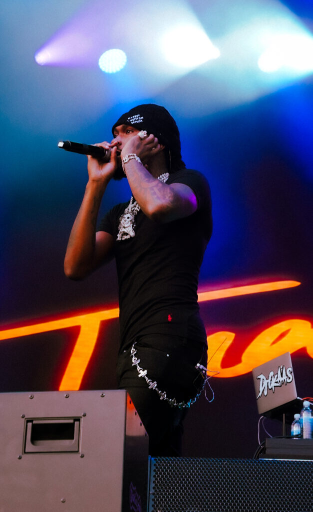 Rapper Hxncho performing on stage while wearing a black t-shirt and black pants.